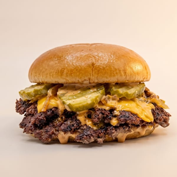 A double smash burger with melted cheese, pickles, and special sauce on a brioche bun.